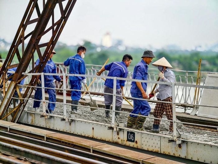 Lực lượng thi công tranh thủ làm việc từ sáng sớm, hạn chế thi công giữa trưa nắng nóng đầu mùa hè tại Hà Nội. Ảnh: Trung Nguyên - TTXVN
