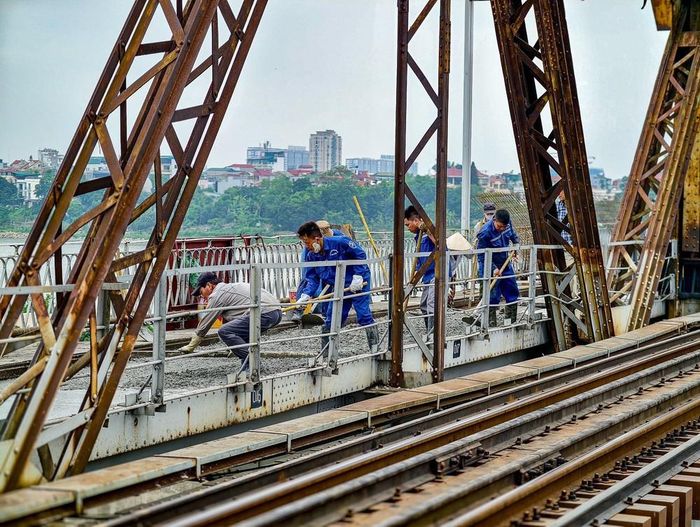 Các mũi thi công được chia nhỏ dọc mặt cầu Long Biên do điều kiện mặt bằng chật hẹp, phương tiện cơ giới lớn không thể tiếp cận. Ảnh: Trung Nguyên - TTXVN