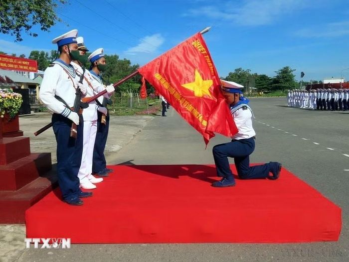 Chiến sỹ mới thực hiện nghi thức hôn lên lá Quân kỳ trong buổi lễ Tuyên thệ trước khi lên đường nhận nhiệm vụ tại các đơn vị thuộc Vùng 2 Hải quân. (Ảnh: Đoàn Mạnh Dương/TTXVN)