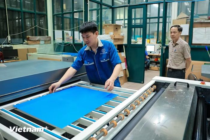 Các kỹ thuật viên đã tập trung rà soát từng chi tiết trên bản kẽm trước khi đưa vào máy. (Ảnh: Hoài Nam/Vietnam+)
