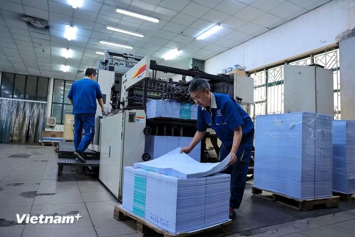 Những dàn máy in hiện đại hoạt động với tốc độ hàng nghìn bản in mỗi giờ. Những cuộn giấy khổng lồ được đưa vào đầu này và ra ở đầu kia là những trang sách phẳng phiu, thơm mùi mực mới. (Ảnh: Hoài Nam/Vietnam+)