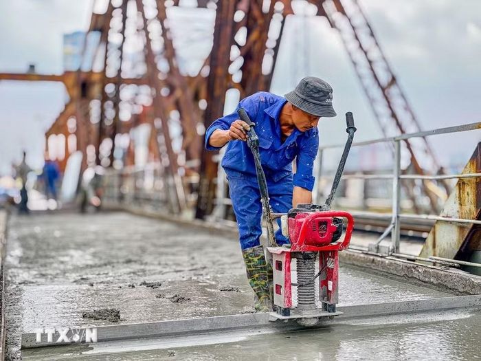Công nhân duy trì thi công 3 ca liên tục trên mặt cầu Long Biên nhằm bảo đảm tiến độ thông cầu vào ngày 27/5/2026. (Ảnh: Trung Nguyên/TTXVN)