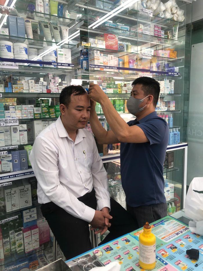 Người y sĩ tận tâm khâu vết thương.