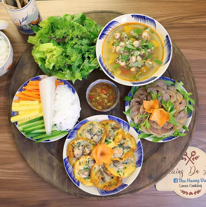 Mâm cơm có món trứng tráng hàu, thịt bê hấp, canh hàu nấu chua.