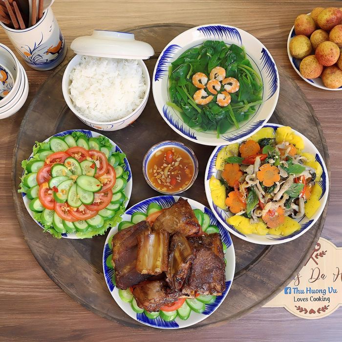 Mâm cơm có món sườn nướng ngũ vị, ốc móng tay xào, canh rau mồng tơi nấu tôm, salad cà chua trộn dưa chuột.