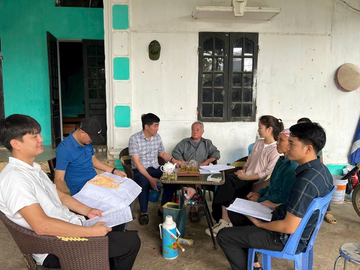 Ông Nguyễn Văn Thá (ngồi thứ 3 bên trái) vận động một hộ dân thôn 3, xã Hòa Lạc đồng thuận kiểm đếm. Ảnh: TH