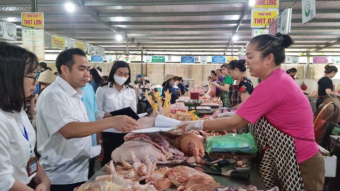 Đoàn kiểm tra số 2 - Sở Nông nghiệp và Môi trường kiểm tra đột xuất về nguồn gốc, xuất xứ tại các quầy hàng bán thịt lợn, gà ở chợ Thượng Thanh (phường Việt Hưng). Ảnh: Ánh Dương