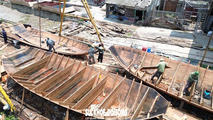 Những người công nhân đang miệt mài với công việc tại xưởng đóng thuyền ba vách. Ảnh: Tiến Sinh.