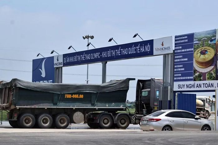 Khu vực cổng vào công trường dự án Khu đô thị thể thao Olympic và Khu đô thị thể thao quốc tế Hà Nội tấp nập xe tải trọng lớn ra vào, phục vụ công tác san lấp và thi công liên tục suốt ngày đêm.
