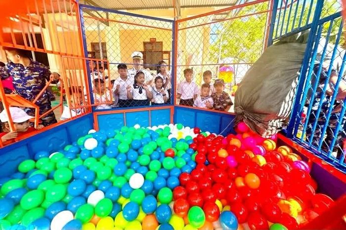 Các em nhỏ trên đảo háo hức xem lắp đặt nhà bóng mới được mang từ đất liền ra đảo. (Ảnh: Minh Nguyệt)