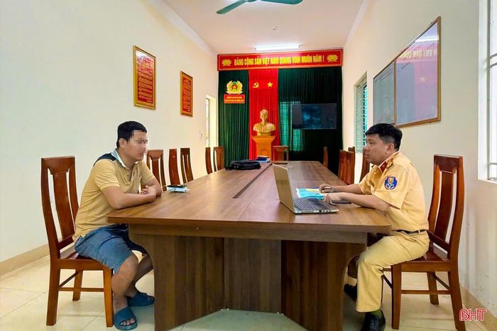 Cán bộ Đội CSGT đường bộ số 2 (Phòng CSGT Công an tỉnh Hà Tĩnh) làm việc với tài xế Trần Ngọc S. để làm rõ về hành vi điều khiển ô tô tải mang BKS 38H - 035.xx đi không đúng làn đường quy định.