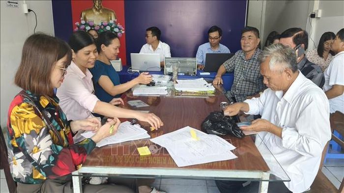 Cán bộ, công chức của Tổ hành chính lưu động phường Vĩnh Trạch tiếp, hỗ trợ công dân soạn các giấy tờ cần thiết để hoàn thiện hồ sơ hành chính.