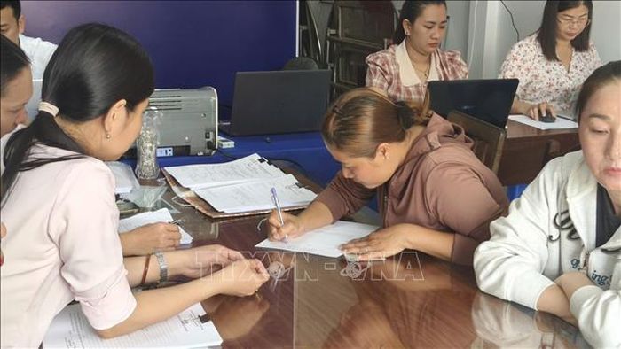 Cán bộ, công chức của Tổ hành chính lưu động phường Vĩnh Trạch giúp người dân kê khai, làm thủ tục theo quy định.