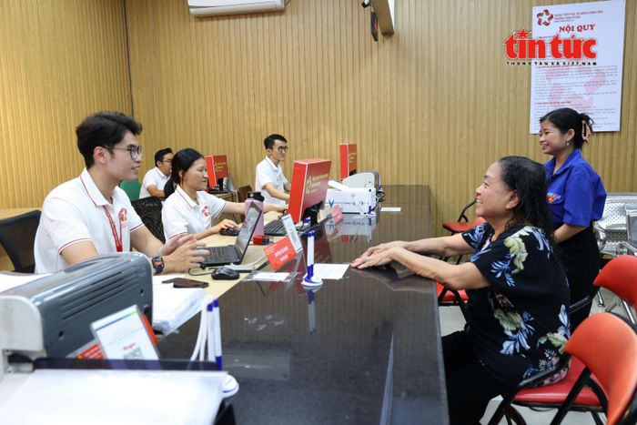 Cán bộ phường Minh Phụng hỗ trợ người dân lớn tuổi thực hiện thủ tục hành chính trực tuyến.