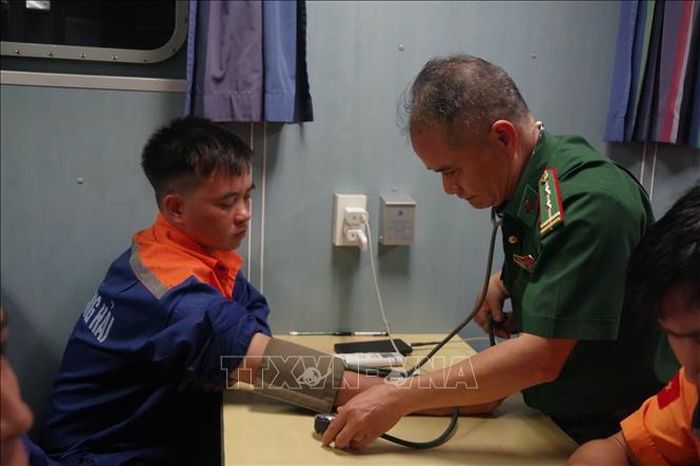 Quân y Biên phòng thăm khám sức khỏe cho thuyền viên bị nạn. Ảnh: TTXVN phát