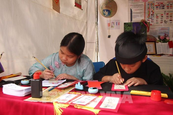 Học sinh viết chữ thư pháp bằng tiếng Pháp, một trong những hoạt động tại Ngày hội Pháp ngữ. Ảnh: Nguyễn Hằng - TTXVN