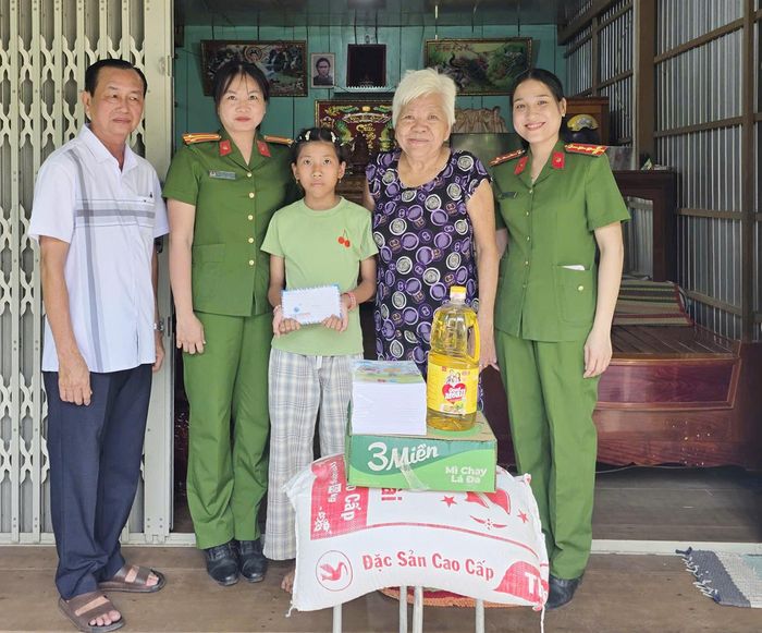 Công an xã Chợ Mới trao quà trong chương trình “Mẹ đỡ đầu” cho em Lê Thị Ngọc Hân. Ảnh: ÚT CHUYỀN