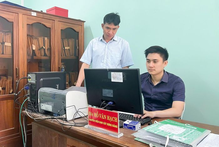 Anh Hồ Nhật Huy (ngồi), hướng dẫn nghiệp vụ cho cán bộ Ban Xây dựng Đảng xã Phước Thành. Ảnh: PV