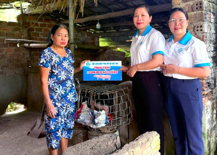 Hội Liên hiệp phụ nữ xã Việt An tặng heo giống cho hội viên có hoàn cảnh khó khăn. Ảnh: THU QUYÊN