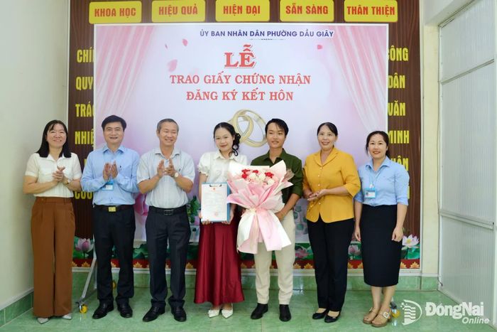 Thành ủy viên, Phó Trưởng ban Tuyên giáo và Dân vận Thành ủy Lê Thị Thái cùng lãnh đạo phường Dầu Giây trao giấy Chứng nhận kết hôn cho cặp đôi tại Trung tâm Phục vụ hành chính công của phường. Ảnh: Phương Hằng