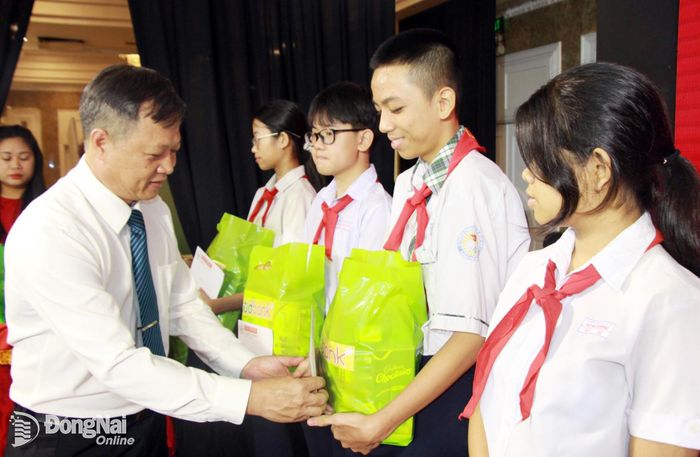 Phó Chủ tịch Ủy ban MTTQ Việt Nam thành phố Nguyễn Tấn Phú trao quà và học bổng cho học sinh có hoàn cảnh khó khăn. Ảnh: Nga Sơn