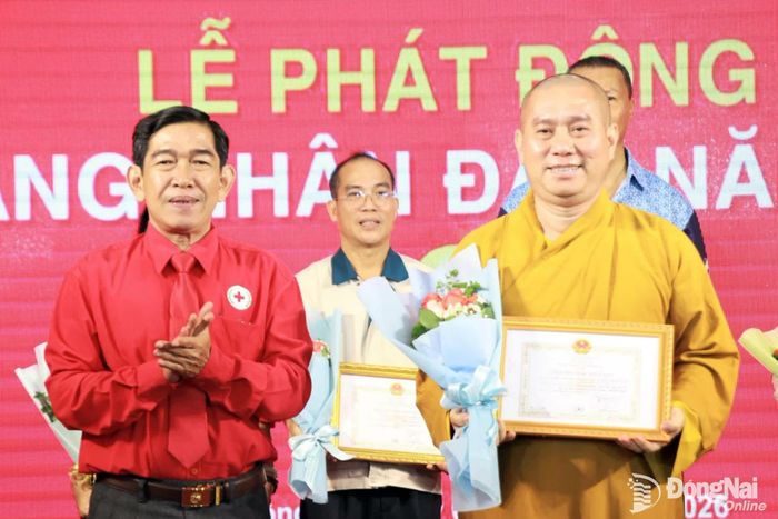 Chủ tịch Hội Chữ thập đỏ thành phố Nguyễn Tấn Hưng trao bảng ghi ơn các đơn vị, cá nhân ủng hộ trong Tháng Nhân đạo. Ảnh: Nga Sơn