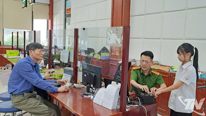 Cán bộ Công an tỉnh thu nhận vân tay để thực hiện thủ tục cấp căn cước công dân cho học sinh.