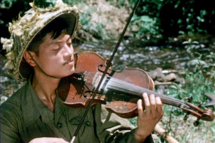 Hình ảnh nhạc sĩ Doãn Nho xuất hiện trong bộ phim "Việt Nam trên đường thắng lợi" khi ông đang chơi đàn violin phục vụ cho chiến sĩ trong giờ nghỉ giải lao trên đường hành quân tham gia Chiến dịch Điện Biên Phủ. (Ảnh: Gia đình cung cấp)