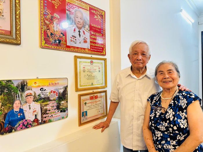 Ông Bùi Gia Tuệ cùng bà Bạch Thị Hoàng Oanh bên những Huân huy chương, khen thưởng cho những cống hiến trong sự nghiệp bảo vệ Tổ quốc. Ảnh: Bảo Lâm