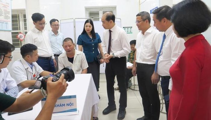 Các đại biểu trò chuyện với người dân đến khám tại Trạm Y tế phường Đại Mỗ.