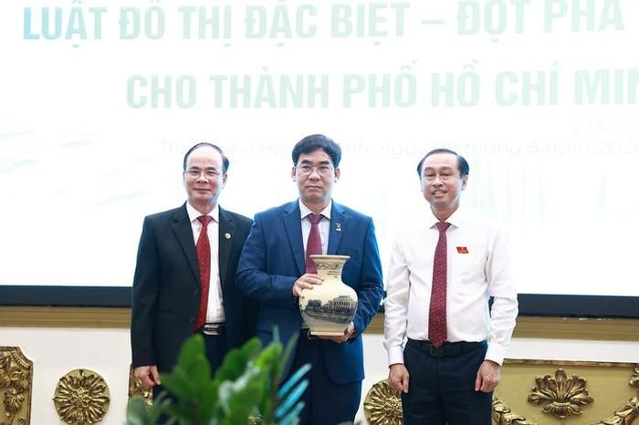 Phó Chủ tịch HĐND TPHCM Huỳnh Thanh Nhân (ngoài cùng bên phải) tặng quà của HĐND TPHCM cho đại diện lãnh đạo Trường Đại học Luật TPHCM