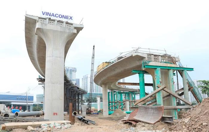 Trên công trường, máy móc hoạt động nhộn nhịp; hệ thống khung thép phục vụ thi công hầm chui và cầu dẫn được lắp dựng đồng bộ, tạo nên không khí thi công khẩn trương.
