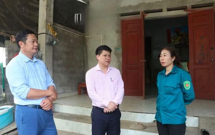 Cán bộ xã Yên Trạch và Ngân hàng Chính sách xã hội trao đổi với chị Đặng Minh Huệ.