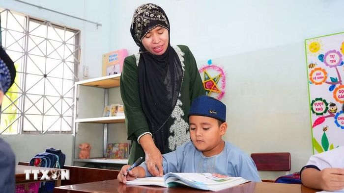 Học sinh dân tộc Chăm tại Trường Tiểu học Lê Văn Tám được giáo viên hướng dẫn luyện đọc, luyện viết tiếng Việt. (Ảnh: Minh Phú/TTXVN)