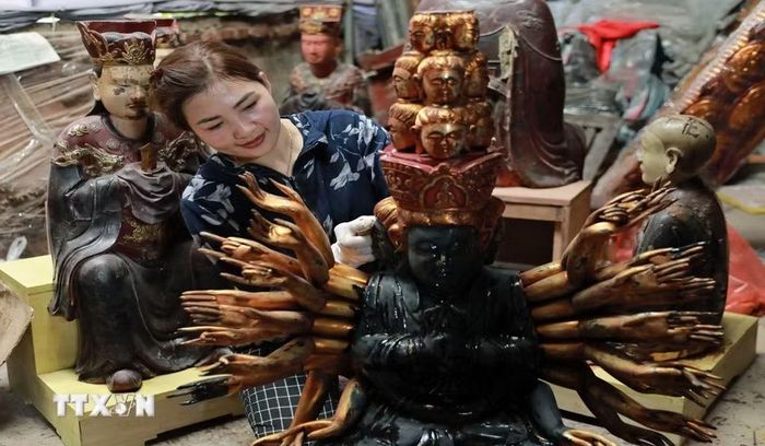 Nghệ nhân làng nghề Sơn Đồng hoàn thiện sản phẩm. (Ảnh: TTXVN phát)