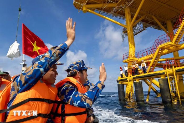 Những cái vẫy tay lưu luyến giữa biển khơi. (Ảnh: Xuân Quý/TTXVN)