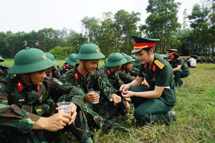 Chị Lương Thị Thanh Nga, hội viên phụ nữ Cơ quan Bộ Tham mưu, Tổng cục Hậu cần - Kỹ thuật tranh thủ khâu lại cúc áo cho chiến sĩ ngay tại thao trường.