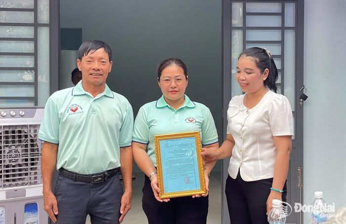 Lãnh đạo xã Lộc Hưng trao thư cảm ơn sự chung tay của các đoàn thiện nguyện. Ảnh: Thu Hiền