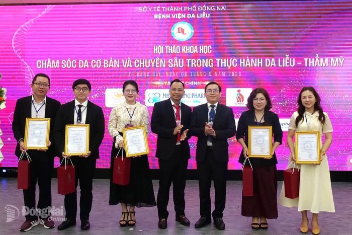 Đại diện bệnh viện và Trường đại học Công nghệ Đồng Nai trao giấy chứng nhận cho thành viên chủ tọa đoàn và các báo cáo viên. Ảnh: Hạnh Dung