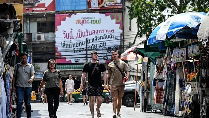 Du khách đi bộ tại một địa điểm ẩm thực nổi tiếng ở Bangkok, Thái Lan. Ảnh: CNA