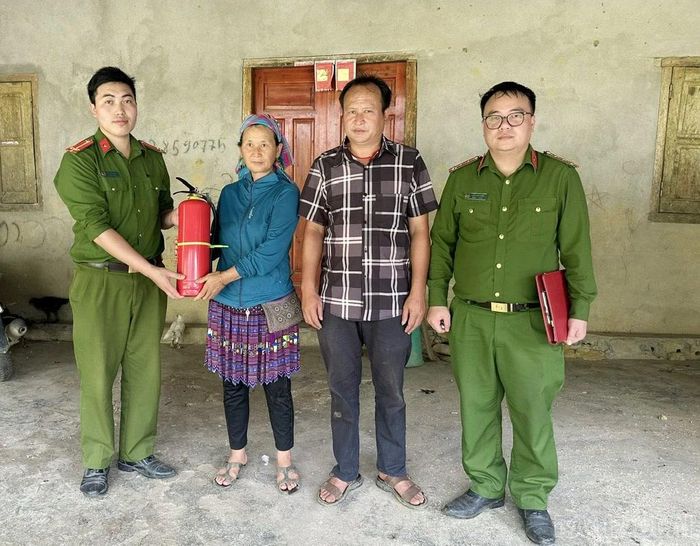 Công an xã Sín Chéng trao tặng bình chữa cháy cho hộ gia đình.