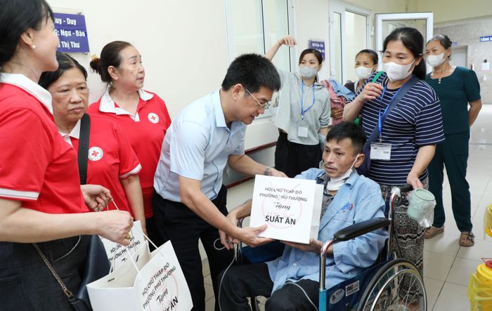 Thành viên Đoàn công tác trao suất ăn đến người bệnh tại Bệnh viện K cơ sở Tân Triều không thể tự đi lại