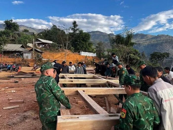 Chiến sĩ Đồn biên phòng Na Cô Sa giúp nhân dân dựng nhà ở mới.