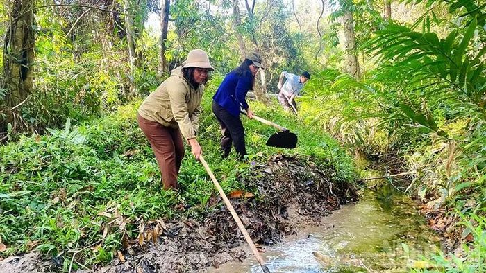 Bí thư Đảng ủy xã Đăk Hà Nguyễn Thị Liên (áo xanh) tham gia hoạt động nạo vét kênh mương thủy lợi cùng người dân.