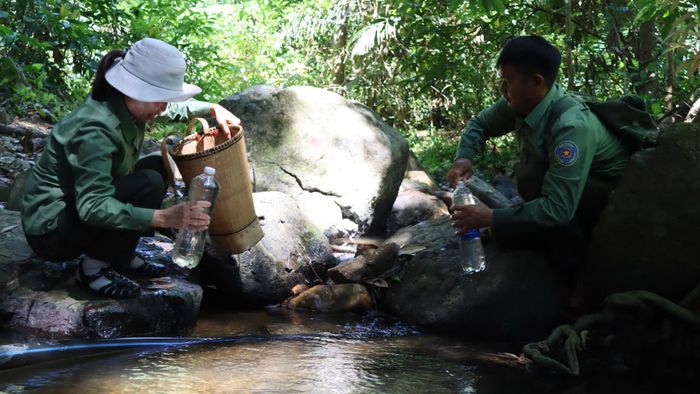  Tranh thủ lấy nước suối về dùng. Ảnh: HỮU PHÚC 