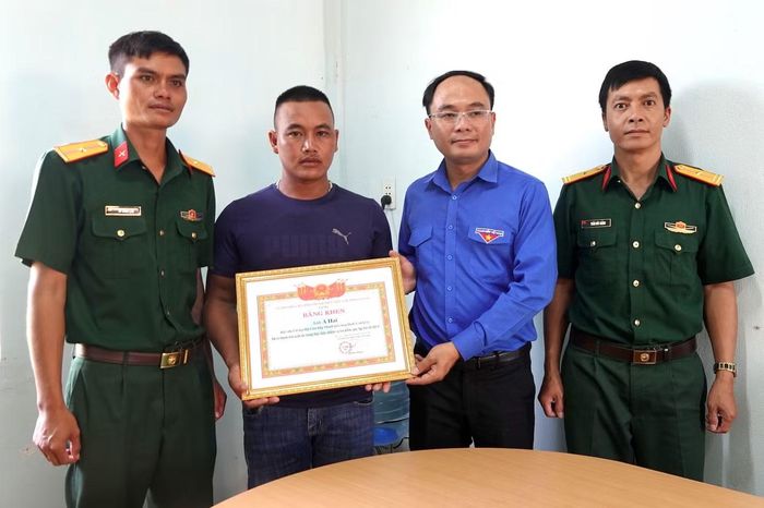 Anh Đỗ Đức Thanh tặng bằng khen cho anh A Hải (thứ 2 bên phải ảnh).