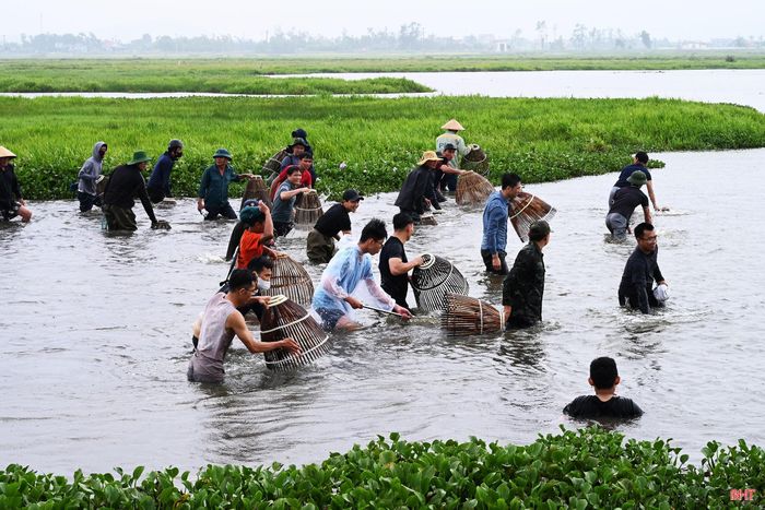Hàng chục người dân trong thôn và vùng lân cận cùng bắt cá, tạo nên khung cảnh náo nhiệt.