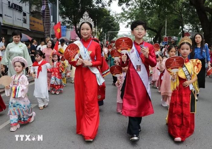 Các em nhỏ tham gia diễu hành trong trang phục truyền thống. (Ảnh: Mạnh Minh/TTXVN)