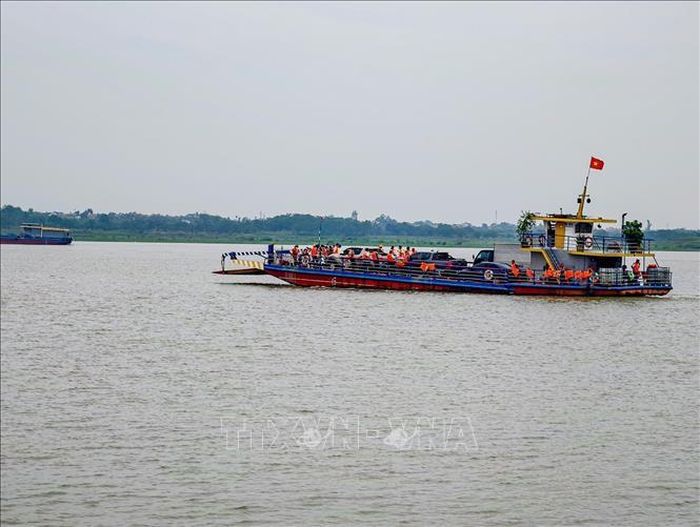 Hành khách mặc áo phao đầy đủ khi di chuyển trên phà qua sông Hồng tại khu vực bến khách ngang sông thuộc địa bàn thành phố Hà Nội.