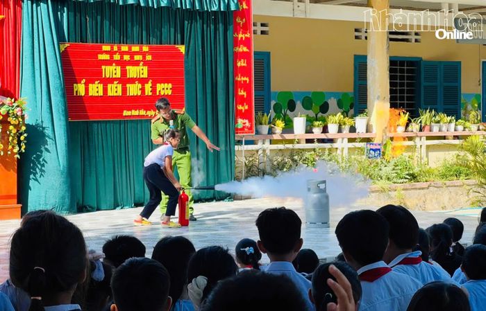 Cán bộ chữa cháy chuyên nghiệp hướng dẫn học sinh Trường Tiểu học Ninh Ích dập lửa bằng bình chữa cháy xách tay.